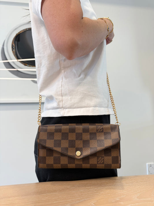 Authentic Louis Vuitton damier ebene Sarah wallet with added removeable strap in pristine condition inside and out ! Fits phones etc retail $935 plus tax !